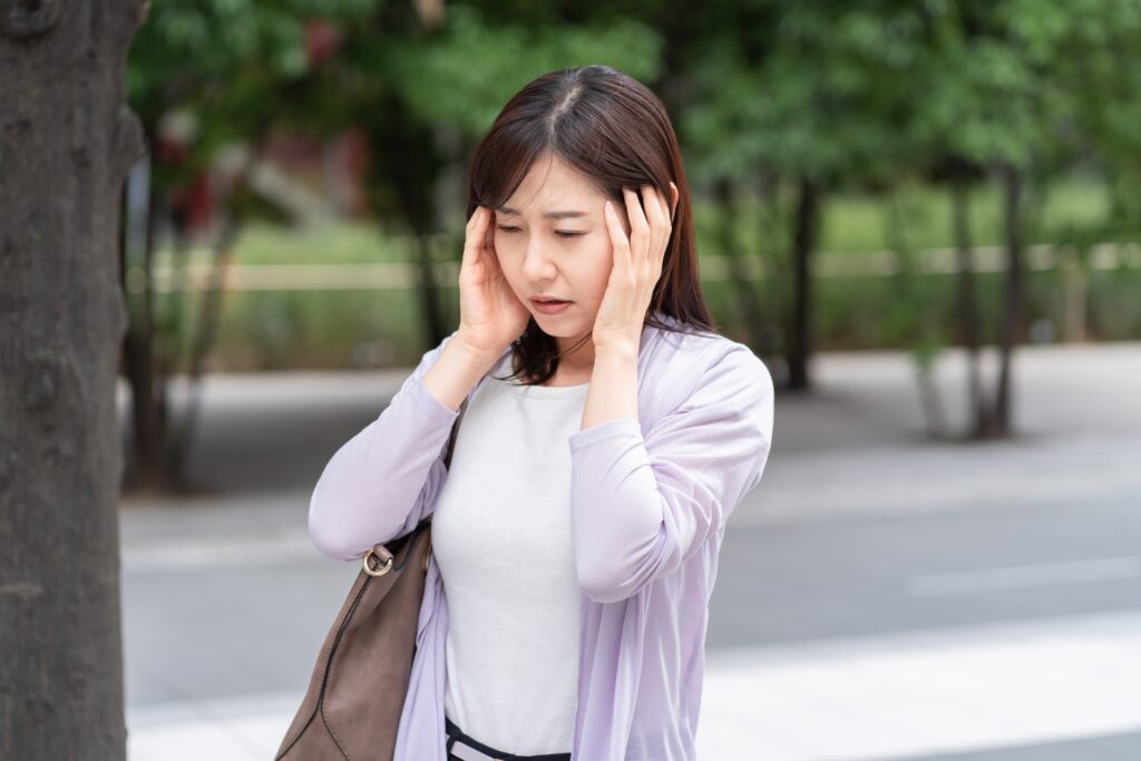 手を頭に当てる女性