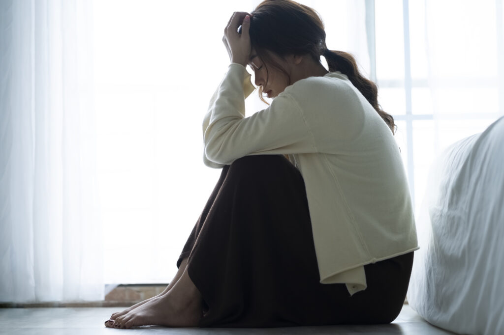 座り込んで頭を抱える女性