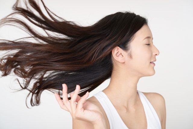 ロングヘアを風になびかせる女性