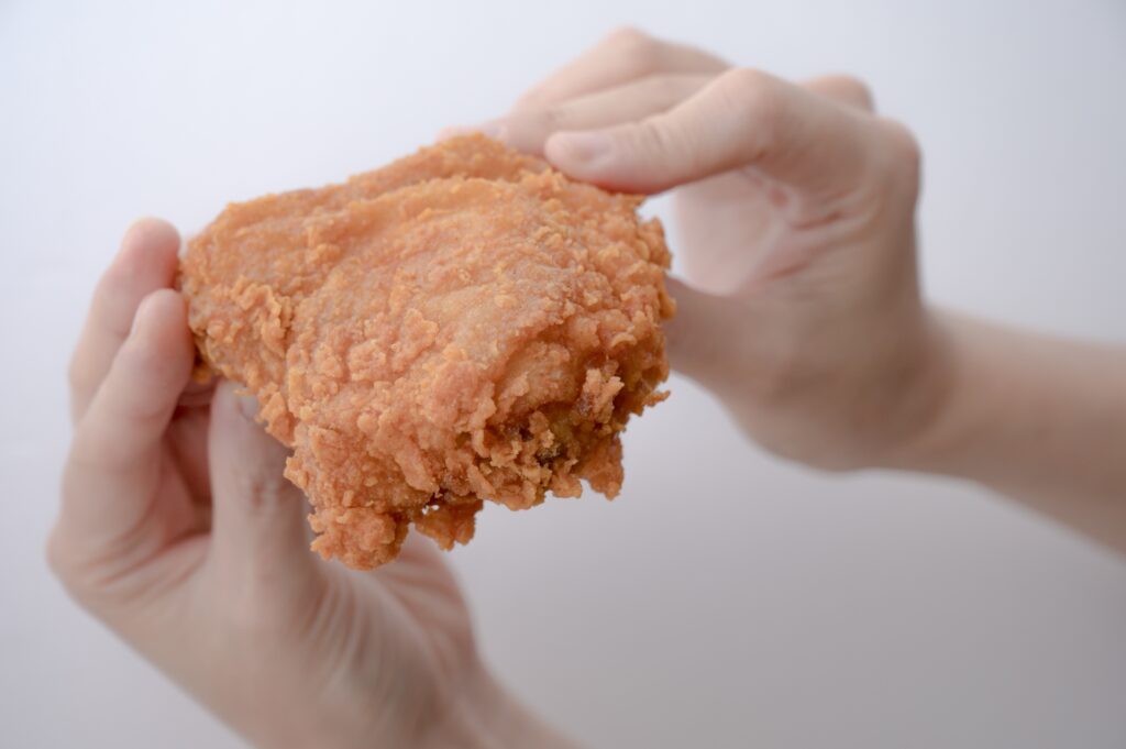 フライドチキンを手で持つ