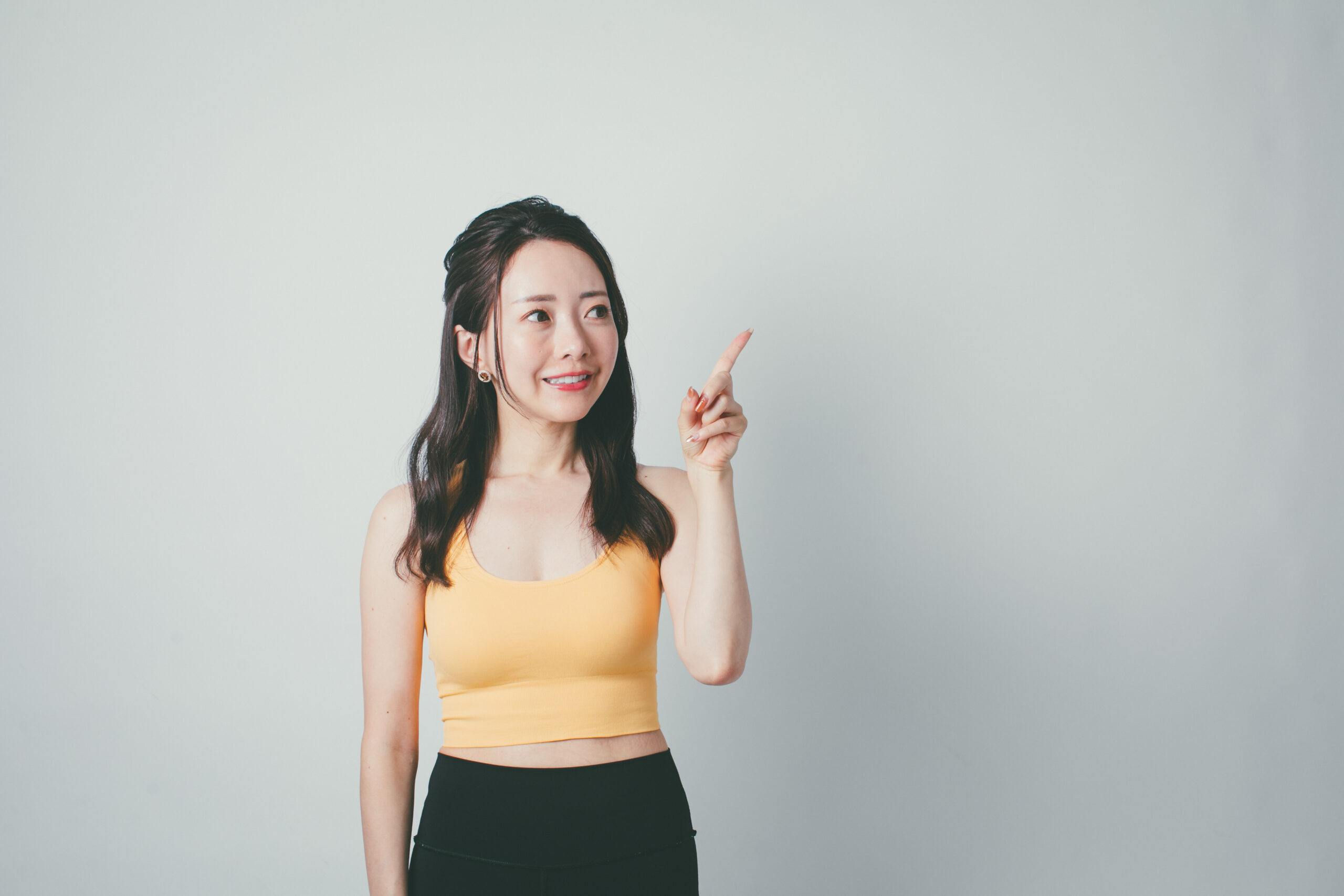 上に指をさす女性