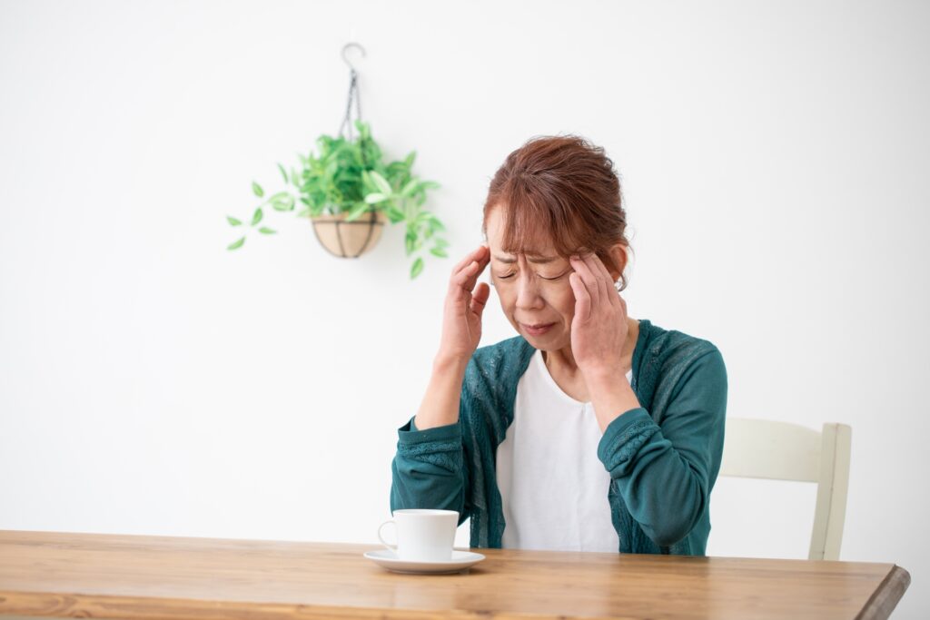 頭を両手で押さえる女性