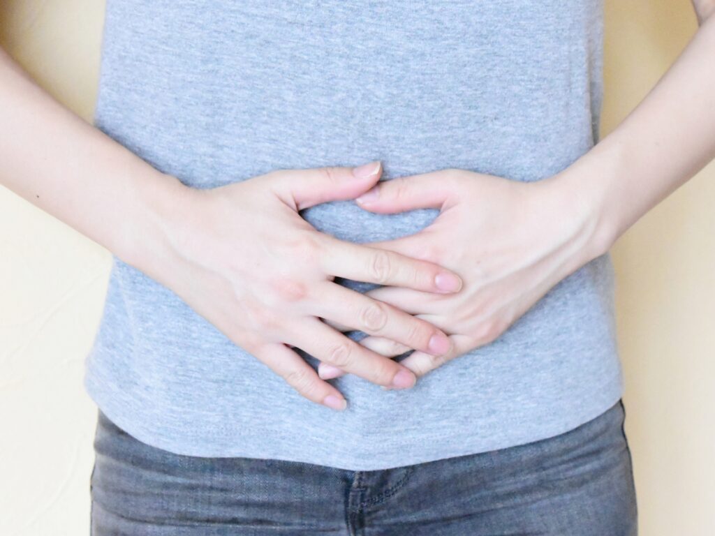 お腹に手をあてる女性