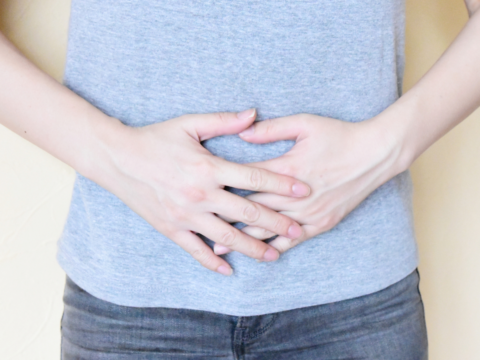 お腹に手をあてる女性