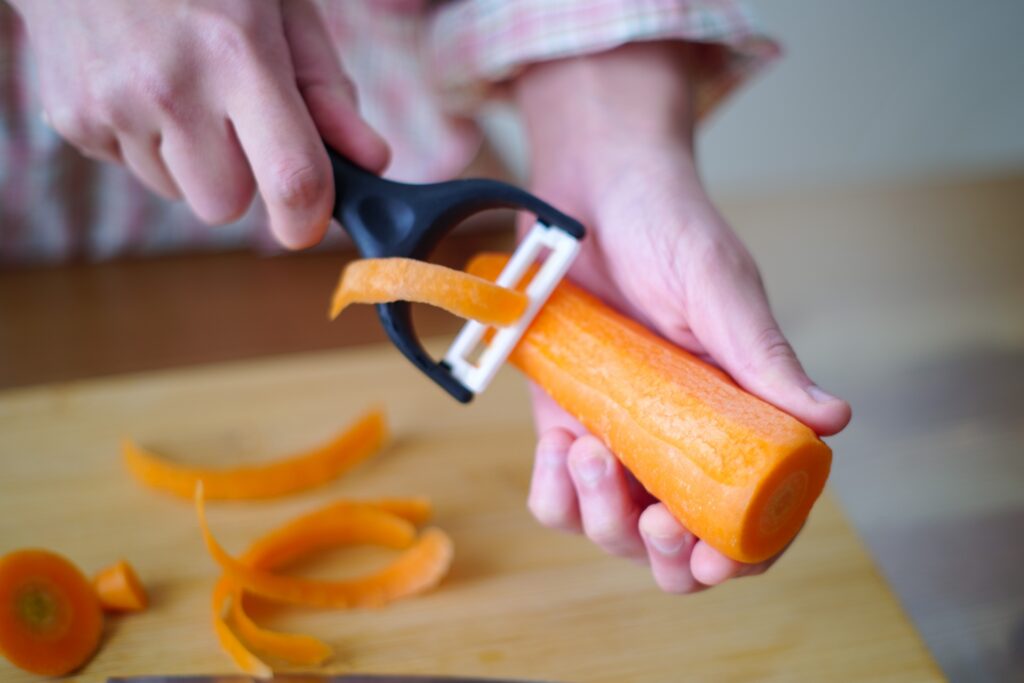 にんじんの皮を剥く女性