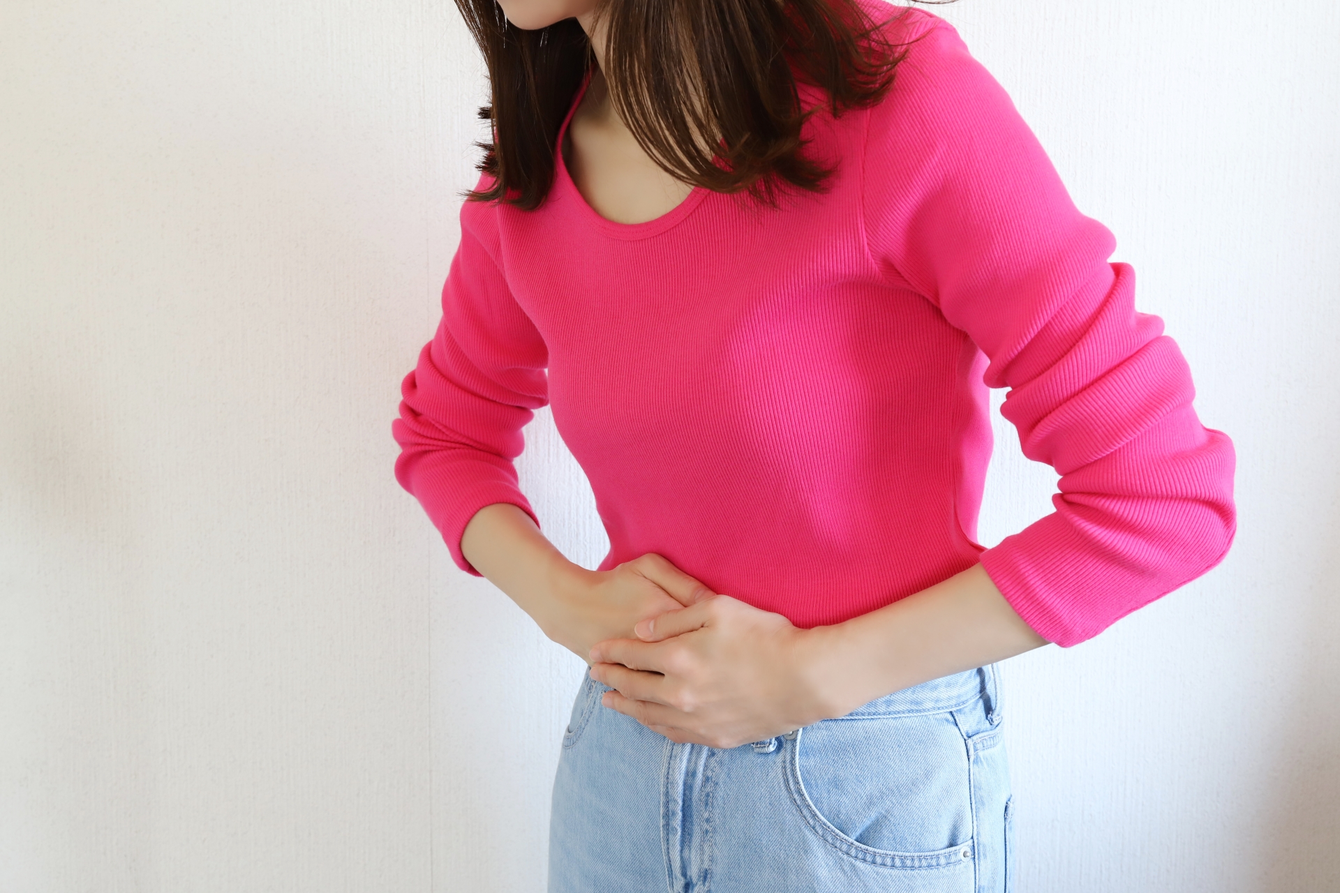 腹痛でお腹を抑える女性