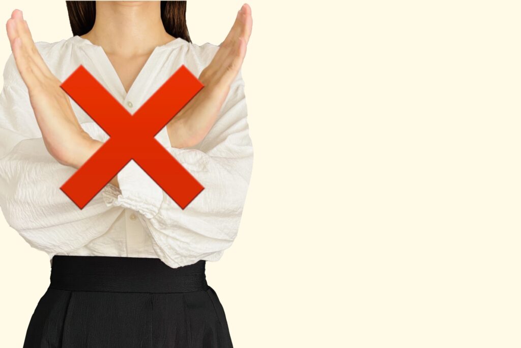 手で×を作る女性