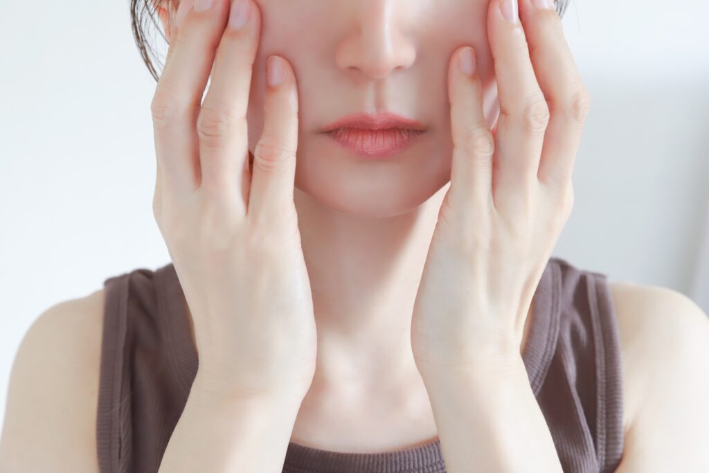 頬を手で触る女性